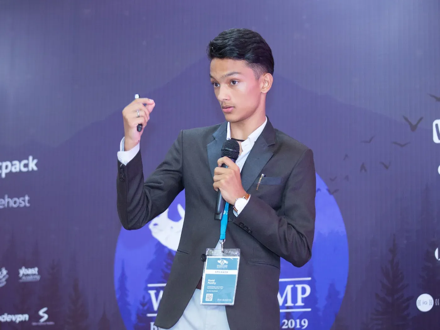 Kovid Panthy speaking with a microphone and a clicker at WordCamp Bharatpur 2019.