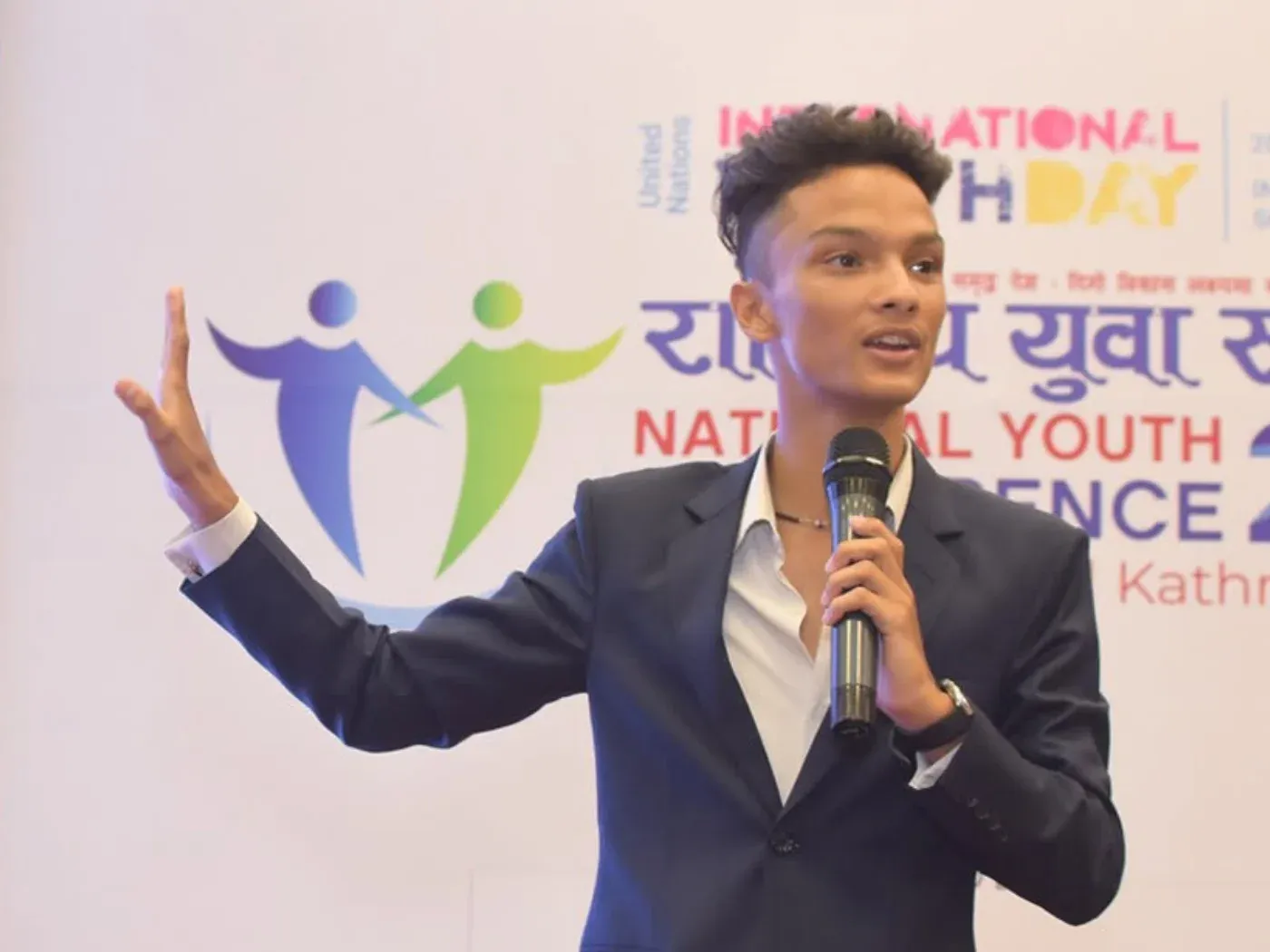 Kovid Panthy speaking into a microphone at the National Youth Conference in Kathmandu.
