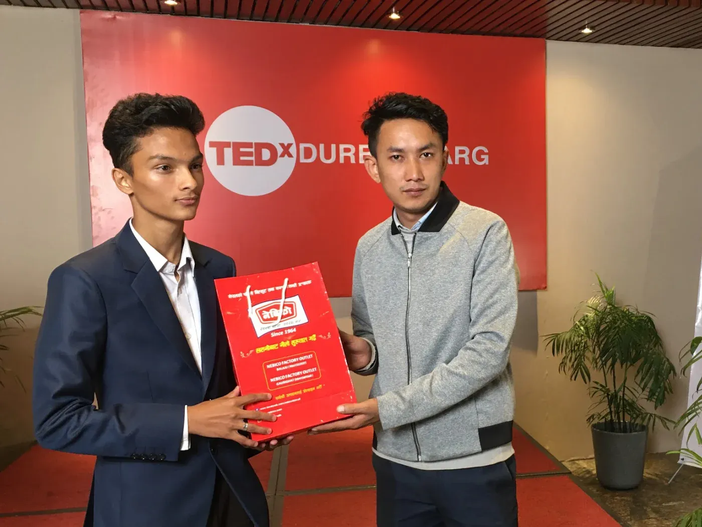 Kovid Panthy being presented with a token of appreciation by a member of the TEDx Durbarmarg team.