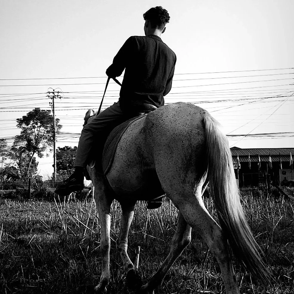 Kovid Panthy riding away from the camera, in black and white.