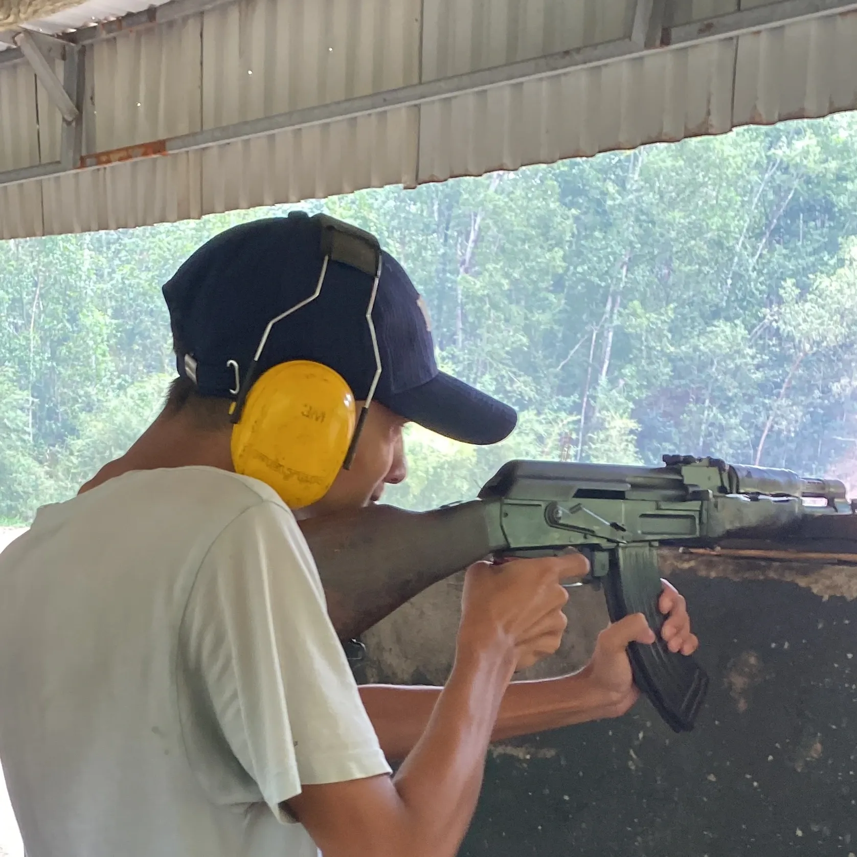 Kovid Panthy sighting down the range in ear defenders.
