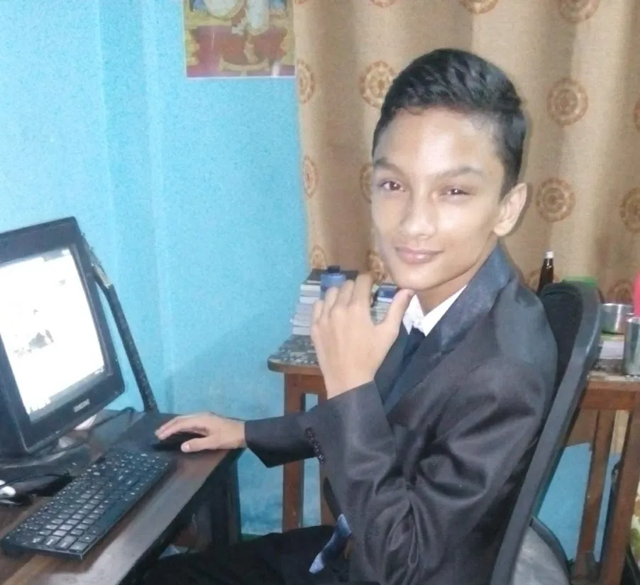 Kovid Panthy as a boy at a CRT monitor and keyboard, turned to the camera.